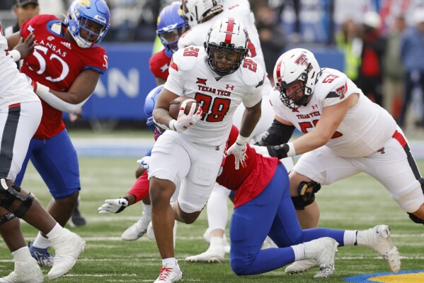 Texas Tech running back Tahj Brooks (28) rushes for a first down during the first half of an NCAA college football game against Kansas, Saturday, Nov. 11, 2023, in Lawrence, Kan. (AP Photo/Colin E Braley)