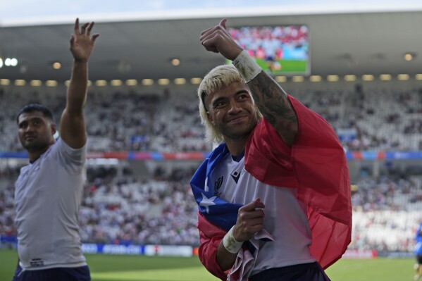 Samoa's Jonathan Taumateine, right, and teammate Sama Malolo celebrate after the Rugby World Cup Pool D match between Samoa and Chile at the Stade de Bordeaux in Bordeaux, France, Saturday, Sept. 16, 2023. (AP Photo/Themba Hadebe)