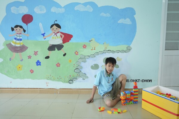 Nguyễn Văn Quốc Hùng, 13 tuổi, chơi xếp hình tại một trường học dành cho nạn nhân chất độc da cam ở Đà Nẵng, Việt Nam, ngày 7 tháng 3 năm 2025. (Ảnh AP/Hau Dinh)