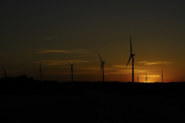 Wind turbines work at sunset on a wind farm near Del Rio, Texas, Feb. 15, 2023. Since passage of the Inflation Reduction Act, it has boosted the U.S. transition to renewable energy, accelerated green domestic manufacturing, and made it more affordable for consumers to make climate-friendly purchases. (AP Photo/Eric Gay)