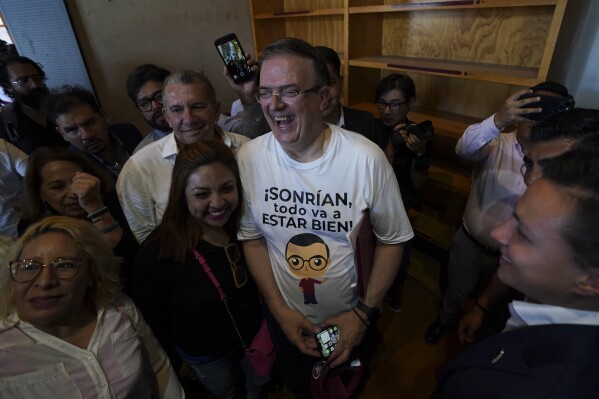 Former Mexican Foreign Minster Marcelo Ebrard, center, shares a laugh with supporters after a news conference at a library in Mexico City, Monday, June 12, 2023. The top diplomat has resigned his post to enter the primary race for the country's June 2, 2024, presidential election, and Mexico City Mayor Claudia Sheinbaum says she will do the same Friday. (AP Photo/Fernando Llano)