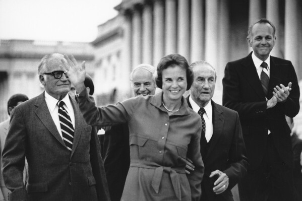 FILE - Sandra Day O'Connor waves as she arrives at the Capitol in this Sept. 10, 1981 black-and-white file photo, shortly after her nomination to the Supreme Court was confirmed by the Senate. From left, Sen. Barry Goldwater, R-Ariz., Attorney General William French Smith, O'Connor, Sen. Strom Thurmond, R-S.C., and Sen. Dennis DeConcini, D-Ariz. O'Connor, who joined the Supreme Court in 1981 as the nation's first female justice, has died at age 93. (AP Photo/Scott Applewhite, File)