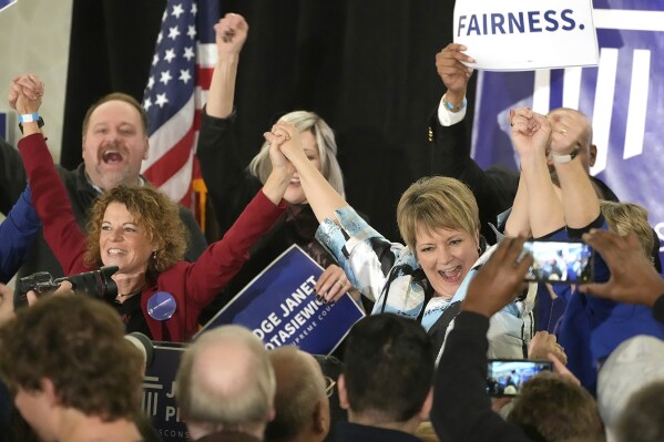 FILE - Supreme Court candidate Janet Protasiewicz, right, holds hands with Wisconsin Supreme Court Justice Rebecca Dallet, left, and Wisconsin Supreme Court Justice Ann Walsh Bradley, blocked from view at far right, at a watch party in Milwaukee, on April 4, 2023. The Wisconsin's Supreme Court flips from majority conservative to liberal control on Aug. 1 when Protasiewicz is set to be sworn in. (Mike De Sisti/Milwaukee Journal-Sentinel via AP, File)