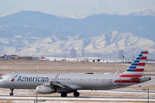 FILE - An American Airlines jetliner rumbles down a runway at Denver International Airport, Jan. 16, 2024, in Denver. American Airlines is lowering some of its second-quarter financial forecasts and has announced the departure of its chief commercial officer. (AP Photo/David Zalubowski, File)