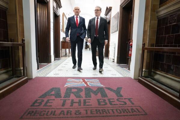 Britain's Labour Party leader Keir Starmer and and shadow Defence Secretary, John Healey walk, during a visit to the Fusilier Museum, Bury in Greater Manchester, England, Monday, June 3, 2024, while on the general election campaign trail. (Stefan Rousseau/PA via AP)
