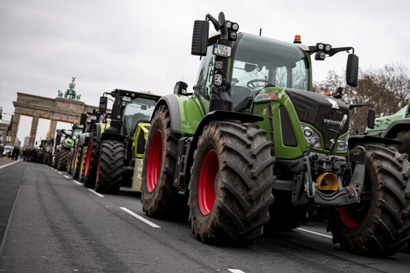 FILE - Farmers with tractors take part in a protest rally organized by the German Farmers' Association in Berlin, Germany, Monday, Dec. 18, 2023. The German government on Thursday watered down cost-saving plans that have infuriated farmers, announcing that it will give up a proposal to scrap an exemption from car tax for farming vehicles and will stagger cuts to tax breaks for diesel used in agriculture. (Fabian Sommer/dpa via AP, File)