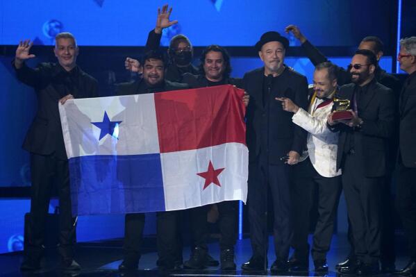 Ruben Blades, third from right, Roberto Delgado, right, and his orchestra accept the award for album of the year for "Salswing!" while holding up the flag of Panama at the 22nd annual Latin Grammy Awards on Thursday, Nov. 18, 2021, at the MGM Grand Garden Arena in Las Vegas. (AP Photo/Chris Pizzello)