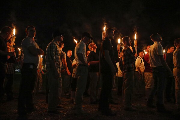 FILE - Multiple white nationalist groups march with torches through the University of Virginia campus on Aug. 11, 2017, in Charlottesville, Va. A Virginia judge declared a mistrial on Thursday, June 6, 2024, in the case of Jacob Joseph Dix, who is charged with using a flaming torch to intimidate counterprotesters during the 2017 gathering of white nationalists. (Mykal McEldowney/The Indianapolis Star via AP, File)