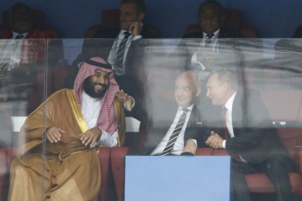 FILE - Saudi Arabia Crown Prince Mohammed bin Salman, left, FIFA President Gianni Infantino, center, and Russian President Vladimir Putin watch the match between Russia and Saudi Arabia which opens the 2018 soccer World Cup at the Luzhniki stadium in Moscow, Russia, on June 14, 2018. If Saudi Arabia could have designed a process for choosing future World Cup hosts, it might look similar to what FIFA unveiled for the 2030 and 2034 men’s soccer tournaments. The Saudi Arabian soccer federation became the favored candidate to host in 2034. (AP Photo/Hassan Ammar, File)