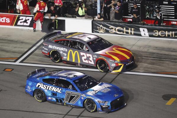 Chris Buescher (17) jumps ahead of Bubba Wallace (23) after a pit stop during the first of two qualifying auto races for the NASCAR Daytona 500 at Daytona International Speedway, Thursday, Feb. 16, 2023, in Daytona Beach, Fla. (AP Photo/David Graham)