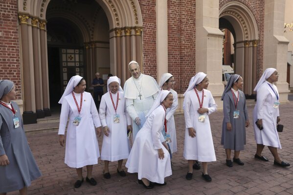 Catholic nuns surround a life size cut out of Pope Francis at the Assumption Cathedral in Bangkok, Thailand, Wednesday, Nov. 20, 2019. Pope Francis is heading to Thailand to encourage members of a minority Catholic community in a Buddhist nation and highlight his admiration for their missionary ancestors who brought the faith centuries ago and endured persecution. (AP Photo/Manish Swarup)
