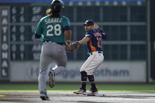 Houston Astros second baseman Jose Altuve (27) forces out Seattle Mariners' Eugenio Suarez (28) and turns a double play against Ty France during the first inning of a baseball game, Saturday, Aug. 19, 2023, in Houston. (AP Photo/Kevin M. Cox)