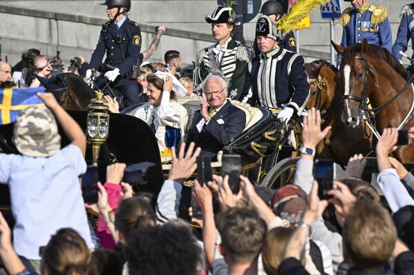 FILE - King Carl XVI Gustaf and Queen Silvia ride in a horse-drawn carriage from the Royal Palace to Skansen for the National Day celebrations in Stockholm, Sweden, Tuesday June 6, 2023. Sweden this week marks the 50th anniversary of King Carl XVI Gustaf’s accession to the throne with four days of celebrations that culminate with a military parade through the capital. (Jonas Ekstromer/TT via AP, File)