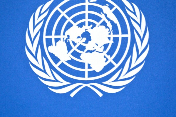 FILE - U.N. logo detail from a press conference background at the United Nations headquarters, Sept. 3, 2013. The United Nations is reporting that global public debt rose to a record $97 trillion last year, with developing countries owing roughly one-third of that – crimping their ability to pay for basic government services like health care, education and climate action. (AP Photo/Bebeto Matthews, file)