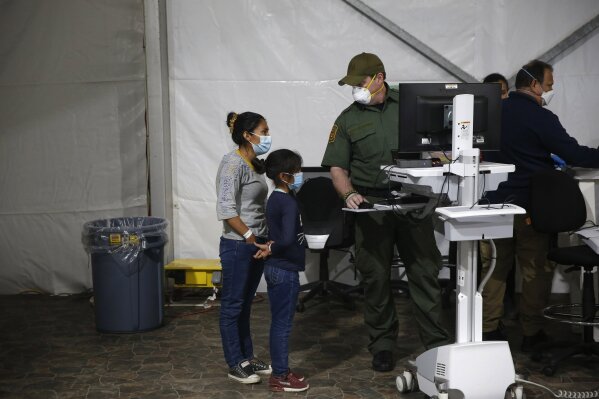 A migrant and her daughter have their biometric data entered at the intake area of the Donna Department of Homeland Security holding facility, the main detention center for unaccompanied children in the Rio Grande Valley, in Donna, Texas, Tuesday, March 30, 2021. (AP Photo/Dario Lopez-Mills,Pool)