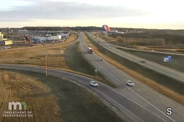 This photo provided by Minnesota Department of Transportation shows a hot air balloon crashing into a power lin in Rochester, Minn., on Wednesday, March 20, 2024. Two people suffered minor injuries as authorities say the basket detached from the balloon and fell about 20 to 30 feet to the ground. (Minnesota Department of Transportation)