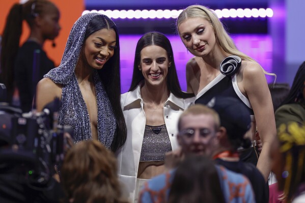 CORRECTS TO CAITLIN CLARK NOT CAITLYN CLARK - From left to right, LSU's Angel Reese, Iowa's Caitlin Clark and Stanford's Cameron Brink pose for a photo before the WNBA basketball draft, Monday, April 15, 2024, in New York. (AP Photo/Adam Hunger)