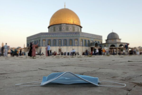 A protective face mask is thrown on the ground during Eid al-Adha prayer, next to the Dome of the Rock Mosque in the Al Aqsa Mosque compound in Jerusalem's old city, Friday, July 31, 2020. This is the first Feast of Sacrifice since the onset of the global coronavirus pandemic. Muslims worldwide marked the the Eid al-Adha holiday over the past days amid a global pandemic that has impacted nearly every aspect of this year's celebrations. (AP Photo/Mahmoud Illean)