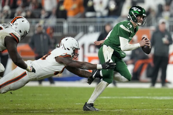 New York Jets quarterback Trevor Siemian breaks away from Cleveland Browns defensive end Alex Wright during the second half of an NFL football game Thursday, Dec. 28, 2023, in Cleveland. (AP Photo/Sue Ogrocki)