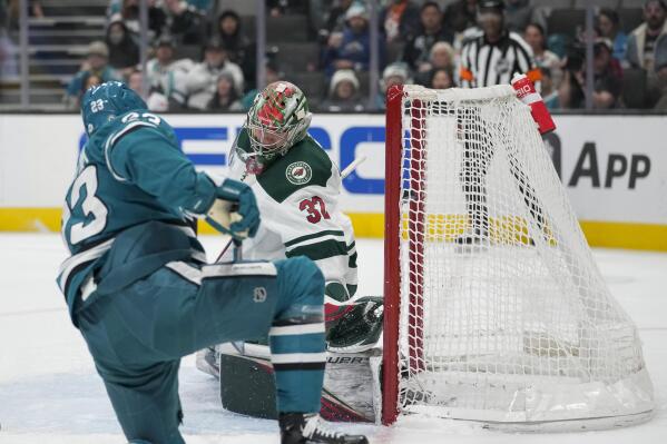 Minnesota Wild goaltender Filip Gustavsson (32) is unable to stop a shot by San Jose Sharks left wing Oskar Lindblom, foreground, for a goal during the second period of an NHL hockey game in San Jose, Calif., Thursday, Dec. 22, 2022. (AP Photo/Godofredo A. Vásquez)
