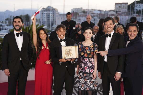 Sean Baker, third from left, winner of the Palme d'Or for the film 'Anora,' poses with Vache Tovmasyan, from left, Samantha Quan, Mikey Madison, Alex Coco and Karren Karagulian during the photo call following the awards ceremony at the 77th international film festival, Cannes, southern France, Saturday, May 25, 2024. (Photo by Scott A Garfitt/Invision/AP)