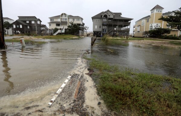 
              Ocean water breeches to the dunes in Avon, N.C., as the first effects of Hurricane Florence reach Hatteras Island on Thursday, Sept. 13, 2018.   (Steve Earley/The Virginian-Pilot via AP)
            