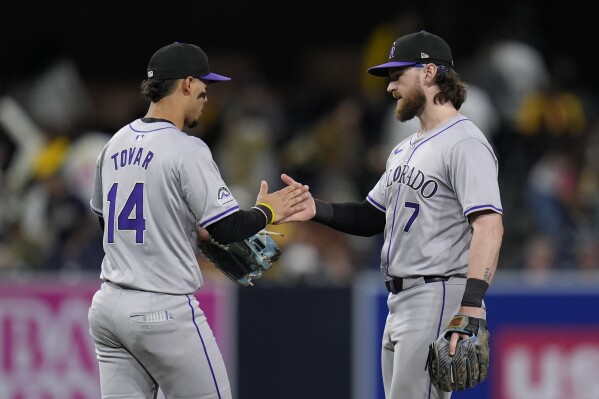 Colorado Rockies shortstop Ezequiel Tovar (14) celebrates with teammate second baseman Brendan Rodgers after the Rockies defeated the San Diego Padres 6-3 in a baseball game, Tuesday, May 14, 2024, in San Diego. (AP Photo/Gregory Bull)