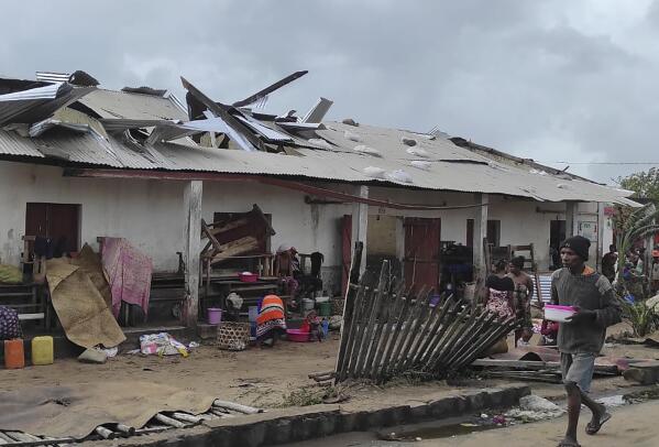A man walks by damaged building, in Mananjary district, Madagascar, Wednesday Feb. 22, 2023 after cyclone Freddy reached Madagascar. A slightly weakened Cyclone Freddy has made landfall in Madagascar, where schools, businesses and public transportation were shut down ahead of its arrival. Freddy was packing winds gusting to 180 kilometers per hour, or about 111 miles per hour, as it came ashore in a nation already hit in January by a tropical storm that killed at least 30 people. (AP Photo/Solofo Rasolofomanana)