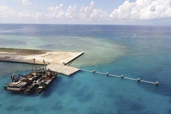 In this photo provided by the Department of National Defense, ships carrying construction materials are docked at the newly built beach ramp at the Philippine-claimed island of Thitu, in the disputed South China Sea, June 9, 2020. The Philippines has sought an explanation from China after a Filipino military commander reported that the Chinese coast guard forcibly seized Chinese rocket debris in the possession of Filipino navy personnel in the disputed South China Sea, officials said Thursday, Nov. 24, 2022. (Department of National Defense PAS via AP)