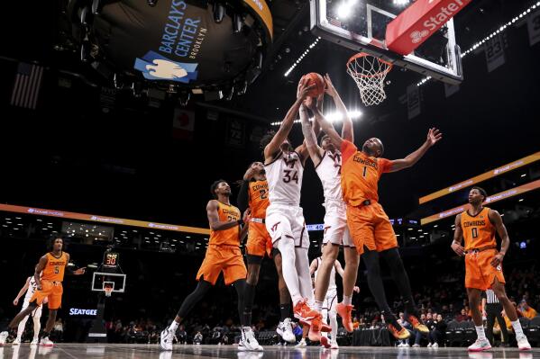 Virginia Tech forward Grant Basile (21), third from right, Virginia Tech forward Mylyjael Poteat (34) and Oklahoma State guard Bryce Thompson (1) rise for the ball during the second half of an NCAA college basketball game in the Basketball Hall of Fame Invitational, Sunday, Dec. 11, 2022, in New York. (AP Photo/Julia Nikhinson)