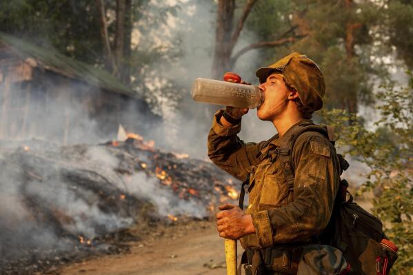 Firefighter Trapper Gephart of Alaska's Pioneer Peak Interagency Hotshot crew takes a drink while battling the Mosquito Fire in the Volcanoville community of El Dorado County, Calif., on Friday, Sept. 9, 2022. (AP Photo/Noah Berger)