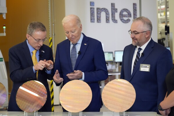 President Joe Biden listens to Intel CEO Pat Gelsinger, left, as Intel factory manager Hugh Green listens, during a tour of the Intel Ocotillo Campus, in Chandler, Ariz., Wednesday March 20, 2024. (AP Photo/Jacquelyn Martin)