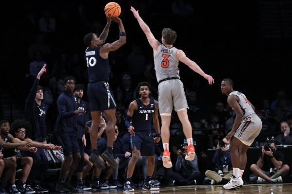 Xavier's Nate Johnson (10) shoots a 3-point basket in front of Virginia Tech's Sean Pedulla (3) in the final seconds of an NCAA college basketball game in the NIT Season Tip-Off tournament Friday, Nov. 26, 2021, in New York. Xavier won 59-58. (AP Photo/Adam Hunger)