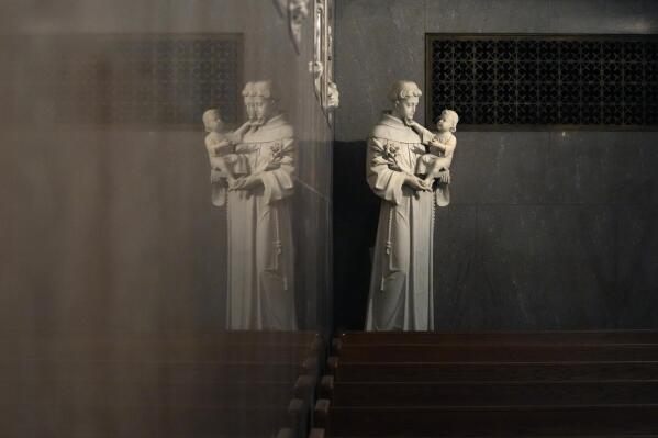 A statue of St. Anthony holding the infant Jesus is reflected in a wall in St. Aloysius Catholic Church, Friday, May 26, 2023, in Detroit. In the year since the Supreme Court struck down the nationwide right to abortion, America's religious leaders and denominations have responded in strikingly diverse ways. The divisions are epitomized in the country's largest denomination – the Catholic Church. National polls repeatedly show that a majority of U.S. Catholics believe abortion should be legal in all or most case, yet the U.S. Conference of Catholic Bishops supports sweeping bans on the procedure. (AP Photo/Carlos Osorio)