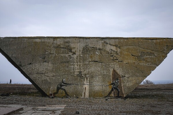 Ukrainian and Russian soldiers are depicted in a tug-of-war game on a memorial in Izium, Kharkiv region, Ukraine, Sunday, March 17, 2024. (AP Photo/Efrem Lukatsky)