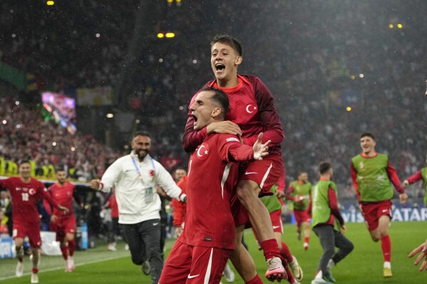 Turkey's Kerem Akturkoglu, bottom, celebrates with his teammate Arda Guler after scoring his side's third goal during a Group F match between Turkey and Georgia at the Euro 2024 soccer tournament in Dortmund, Germany, Tuesday, June 18, 2024. (AP Photo/Alessandra Tarantino)