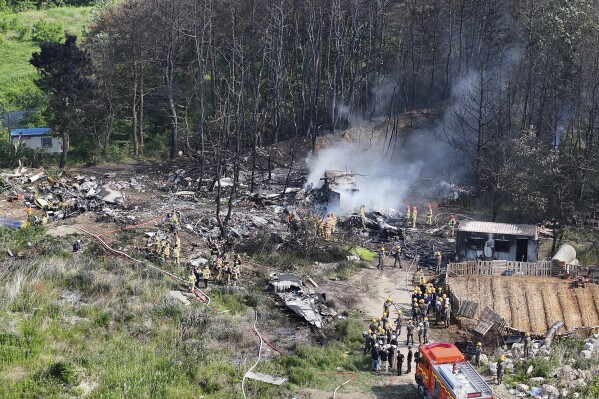 South Korean firefighters and military officers work at the scene of a South Korean navy plane's crash in Pohang, South Korea, Thursday, May 29, 2025. (Yun Kwan-shik/Yonhap via AP)
