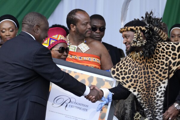FILE - South Africa's President Cyril Ramaphosa, left, shakes hand with King Misuzulu kaZwelithini as he hands over a certificate of recognition at the Moses Mabhida Stadium in Durban, South Africa, on Oct. 29, 2022. A South African court has overturned President Cyril Ramaphosa’s decision to recognize Misuzulu kaZwelithini as the king of the country’s 15 million-strong Zulu nation in what may spark a lengthy battle for the throne.(AP Photo/Themba Hadebe, File)