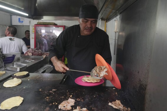 Newly minted Michelin-starred chef Arturo Rivera Martínez prepares an order of tacos at the Tacos El Califa de León taco stand, in Mexico City, Wednesday, May 15, 2024. Tacos El Califa de León is the first ever taco stand to receive a Michelin star from the French dining guide. (AP Photo/Fernando Llano)