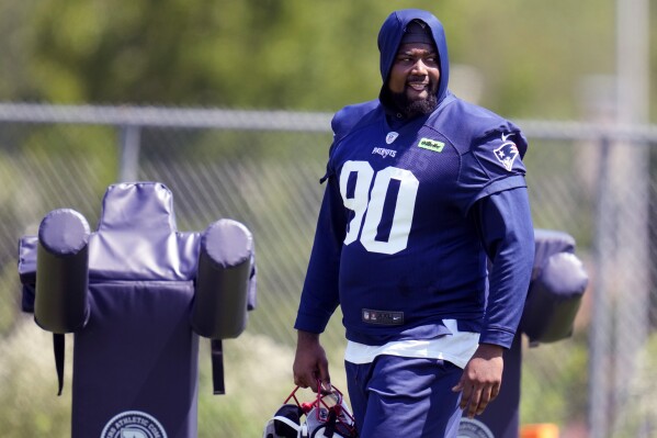 New England Patriots defensive tackle Christian Barmore (90) watches his teammates practice during an NFL football training camp, Friday, July 26, 2024, in Foxborough, Mass. (AP Photo/Charles Krupa)