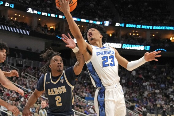 Creighton's Trey Alexander (23) goes for a lay up against Akron's Greg Tribble (2) during the first half of a college basketball game in the first round of the NCAA men's tournament in Pittsburgh, Thursday, March 21, 2024. (AP Photo/Gene J. Puskar)