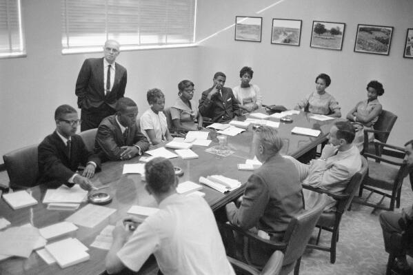 FILE - These eight African-Americans were the first in the history of Memphis State University to register for classes at the formally all white school in Memphis, Tenn., Sept. 10, 1959. At a press conference during registration are from left, Ralph Prater, Luther McClellan, Joyce Gandy, Bertha Rogers, John Simpson, Rosie Blakney, Sammie Burnett and Marvis Kneeland. Dean R.M. Robison is in background. Prater, one of the first Black students to enroll at then-Memphis State University in 1959, died on Sunday, Aug. 7, 2022. He was 81. (AP Photo/Perry Aycock, File)