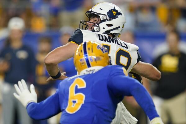 West Virginia quarterback JT Daniels (18) gets off a pass as Pittsburgh defensive lineman John Morgan III (6) closes in during the first half of an NCAA college football game Thursday, Sept. 1, 2022, in Pittsburgh. (AP Photo/Keith Srakocic)