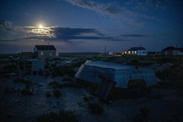 A worn-out boat sits along the dried Aral Sea, in the village of Tastubek near Aralsk, Kazakhstan, Sunday, July 2, 2023. The demise of the once-mighty sea has affected thousands of residents and their livelihoods for decades. (AP Photo/Ebrahim Noroozi)