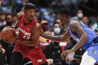 Miami Heat forward Jimmy Butler (22) is defended by Dallas Mavericks forward Dorian Finney-Smith (10) during the first half of an NBA basketball game Tuesday, Nov. 2, 2021, in Dallas. (AP Photo/Brandon Wade)