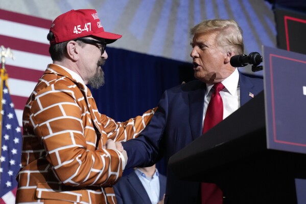 Republican presidential candidate former President Donald Trump greets supporter Blake Marnell as he speaks at a caucus night party in Des Moines, Iowa, Monday, Jan. 15, 2024. (AP Photo/Andrew Harnik)
