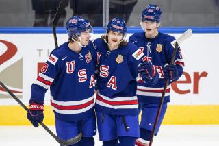 FILE - United States' Jake Sanderson, from left, Tanner Dickinson and Chaz Lucius celebrate a goal against Finland during the first period of an exhibition game in Edmonton, Alberta, Dec. 23, 2021, before the IIHF World Junior Hockey Championship tournament. Sanderson, who plays hockey for the University of North Dakota, was named to the 2022 U.S. Olympic team after the NHL announced it was not sending players to the Olympics. (Jason Franson/The Canadian Press via AP, File)