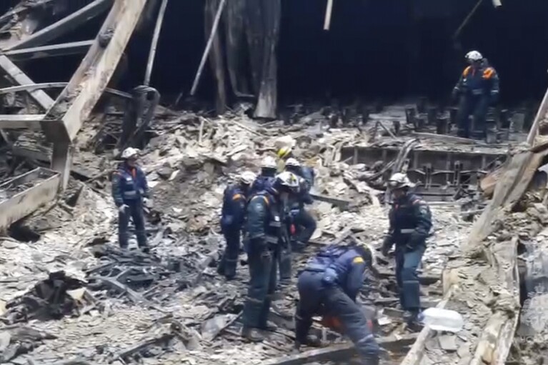 In this photo taken from video released by Russian Emergency Ministry Press Service on Sunday, March 24, 2024, rescuers work in the burned concert hall after a terrorists attack on the building of the Crocus City Hall on the western edge of Moscow, Russia. Russia's top state investigative agency says the death toll in the Moscow concert hall attack has risen to 133. The attack Friday on Crocus City Hall, a sprawling mall and concert venue on Moscow's western edge, also left many wounded and left the building a smoldering ruin. (Russian Emergency Ministry Press Service via AP)