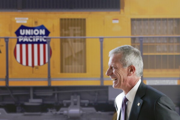 FILE- Union Pacific Chairman, President, and CEO Lance Fritz smiles after a news conference at the Durham Museum in Omaha, Neb., on Feb. 17, 2017. Union Pacific announced Wednesday, July 26, 2023, it has replaced Fritz with its former chief operating officer Jim Vena as the new CEO. The Soroban Capital Partners hedge fund that holds a $1.6 billion stake in Union Pacific had been urging the railroad to hire Vena because of his expertise in streamlining operations.(AP Photo/Nati Harnik, File)