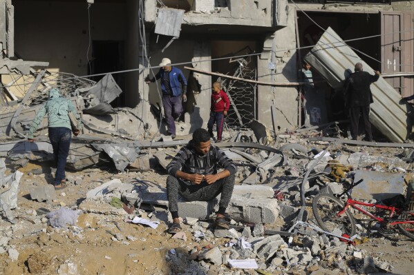 Palestinians look at the destruction by the Israeli bombardment of the Gaza Strip in Rafah, Monday, Dec. 4, 2023. (AP Photo/Hatem Ali)